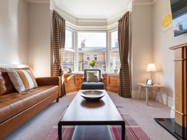 A living room with a sofa, table, and lamp at 18 Mayville Avenue, Scarborough