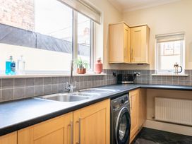 A kitchen with sink and washing machine at 18 Mayville Avenue Scarborough