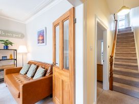 A living room with a sofa and staircase at 18 Mayville Avenue Scarborough