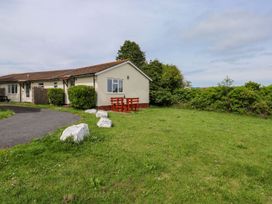 A house with a table and chairs in the garden at Cottage 28 in Brixham