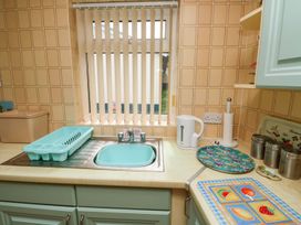 A kitchen with a sink, kettle and storage containers at Cottage 28 in Brixham