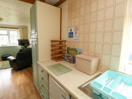 A kitchen with a sink and storage in Cottage 28 Brixham