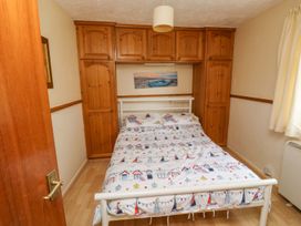 A bedroom with a bed and wardrobe at Cottage 28 in Brixham