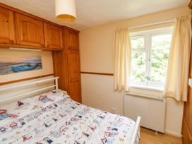 A bedroom with a bed and wardrobe at Cottage 28 in Brixham