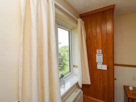 A bedroom with a window and curtains at Cottage 28 in Brixham