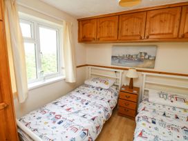 A bedroom with two beds and a nightstand at Cottage 28 in Brixham