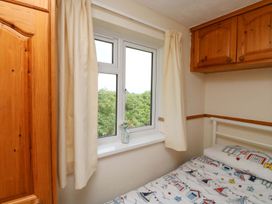 A bedroom with a bed and window at Cottage 28 in Brixham