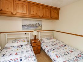 A bedroom with two beds and a bedside table at Cottage 28 in Brixham
