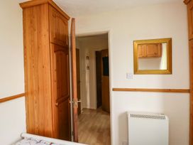 A bedroom with a wardrobe and a mirror at Cottage 28 in Brixham