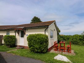 A house with a table and benches outside at Cottage 28 in Brixham