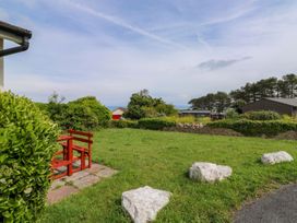 A garden with a bench and rocks at Cottage 28 in Brixham