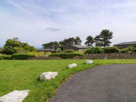 A view of grass, trees, buildings, and a road at Cottage 28 in Brixham