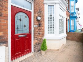 An entrance with a red door and a potted plant at 23 Trafalgar Road Scarborough