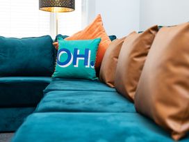 A living room with a teal sofa and cushions at 23 Trafalgar Road in Scarborough