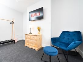 A living room with a television, armchair and chest of drawers at 23 Trafalgar Road in Scarborough