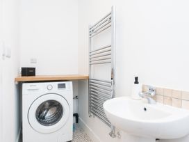 A laundry room with a washing machine and sink at 23 Trafalgar Road Scarborough
