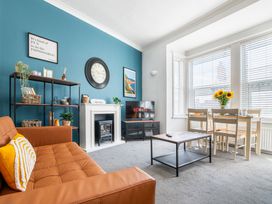 A living room with a sofa and dining area at 53A Hampton Road Scarborough