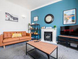 A living room with a sofa, coffee table, and television at 53A Hampton Road in Scarborough