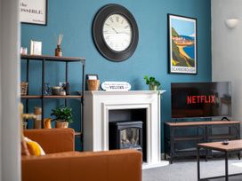 A living room with a television and clock at 53A Hampton Road Scarborough