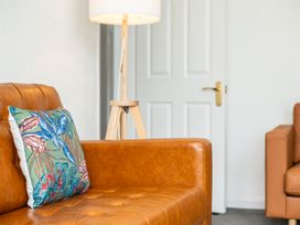 A living room with a brown sofa and a lamp at 53A Hampton Road Scarborough