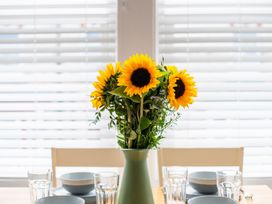 A dining table with sunflowers in a vase at 53A Hampton Road Scarborough