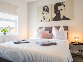 A bedroom with a bed and paintings at 53A Hampton Road Scarborough