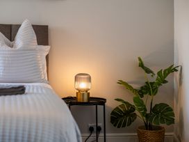 A bedroom with a bed, lamp, and plant at 53A Hampton Road Scarborough