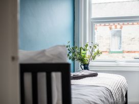 A bedroom with a bed and plant by the window at 53A Hampton Road, Scarborough