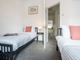 A bedroom with two beds and a table at 53A Hampton Road, Scarborough