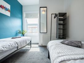 A bedroom with two beds and a mirror at 53A Hampton Road Scarborough