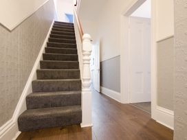 A staircase with gray carpeting in a hallway at 46 Ashville Avenue Scarborough