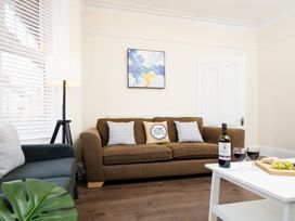 A living room with a sofa and wine on a table at 46 Ashville Avenue Scarborough