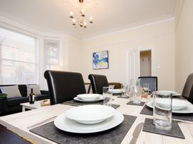 A dining room with a table set for meals at 46 Ashville Avenue, Scarborough