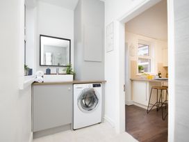 A laundry room with a washing machine and mirror at 46 Ashville Avenue in Scarborough