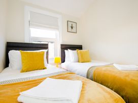 A bedroom with two beds and a lamp at 46 Ashville Avenue Scarborough