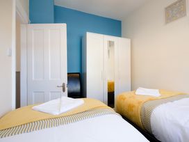 A bedroom with two beds and a wardrobe at 46 Ashville Avenue, Scarborough