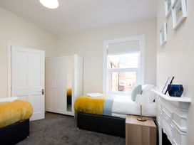A bedroom with two beds and a wardrobe at 46 Ashville Avenue in Scarborough