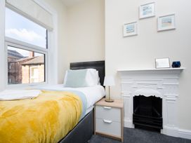 A bedroom with a single bed, side table and wall art at 46 Ashville Avenue in Scarborough