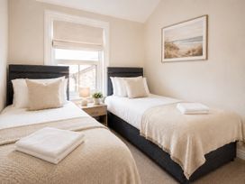 A bedroom with two beds and a painting at 46 Ashville Avenue Scarborough