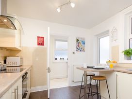 A kitchen with a countertop and bar stools at 46 Ashville Avenue in Scarborough