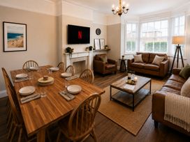 A dining room with a table set and a sofa area at 46 Ashville Avenue Scarborough