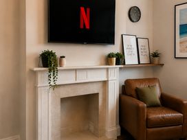 A living room with a TV above a fireplace at 46 Ashville Avenue, Scarborough