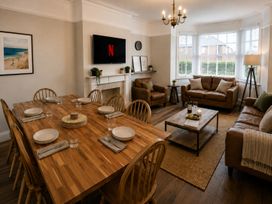 A dining room with a table and seating at 46 Ashville Avenue Scarborough