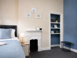 A bedroom featuring a bed, nightstand, and fireplace at 46 Ashville Avenue in Scarborough