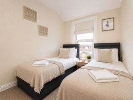 A bedroom with two single beds and a bedside table at 46 Ashville Avenue, Scarborough