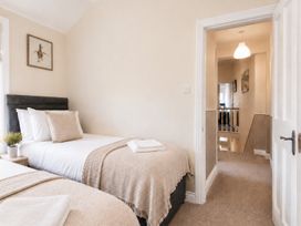A bedroom with two beds and a doorway leading to hallway at 46 Ashville Avenue Scarborough