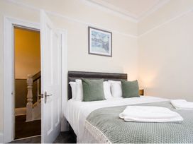 A bedroom with a bed and a door leading to stairs at 46 Ashville Avenue Scarborough