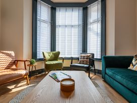 A living room with a sofa, armchairs, coffee table and window blinds at 22 Ashville Avenue, Scarborough