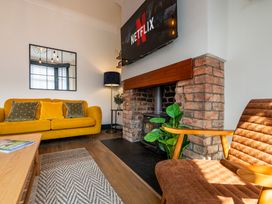 A living room with a yellow sofa and a television at 22 Ashville Avenue in Scarborough