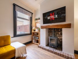 A living room with a TV mounted above a fireplace and a window at 22 Ashville Avenue Scarborough